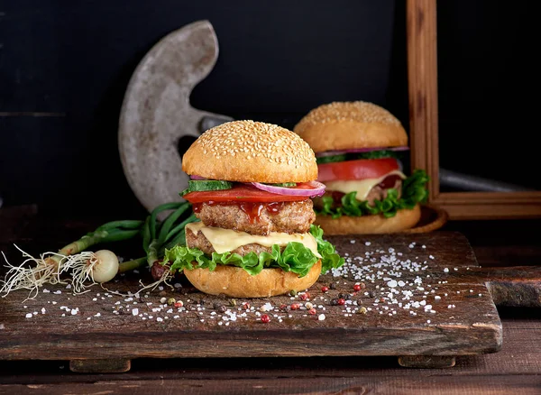 Grote hamburger met twee gebakken schnitzels, kaas en groenten — Stockfoto