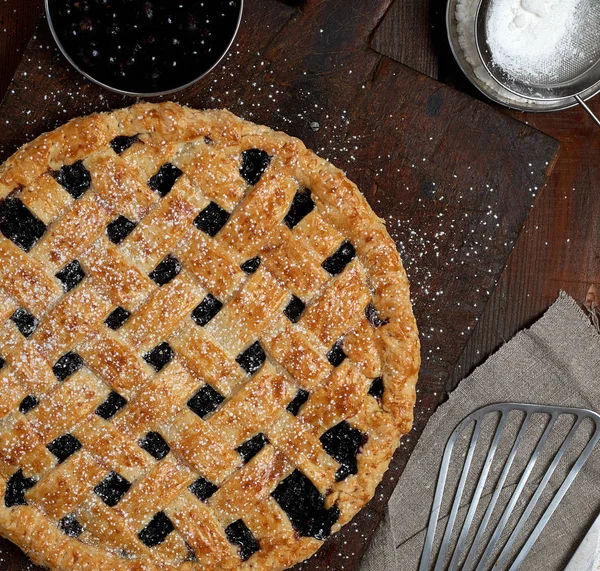 Ronde zwarte bessen taart gebakken en met poedersuiker in poedervorm — Stockfoto