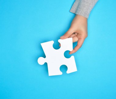 beyaz boş kağıt bulmaca tutan kadın el, mavi arka plan
