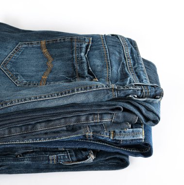 Beyaz arka planda katlanmış mavi kot pantolon yığını