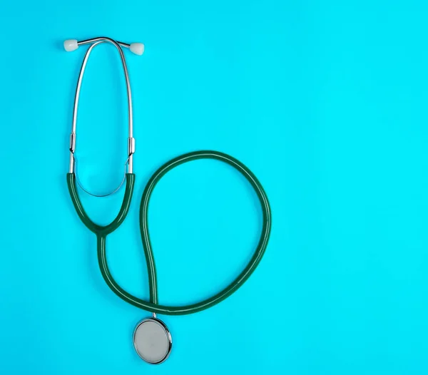 green medical stethoscope on blue background