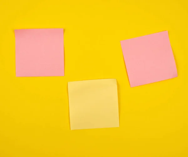 Pegatinas de papel rosa y amarillo pegadas sobre fondo amarillo , — Foto de Stock