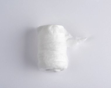 Beyaz bir arka planda beyaz tıbbi pamuk rulo içine bükülmüş