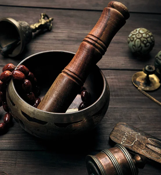 Cuenco de cobre y un palo de madera en una mesa marrón — Foto de Stock