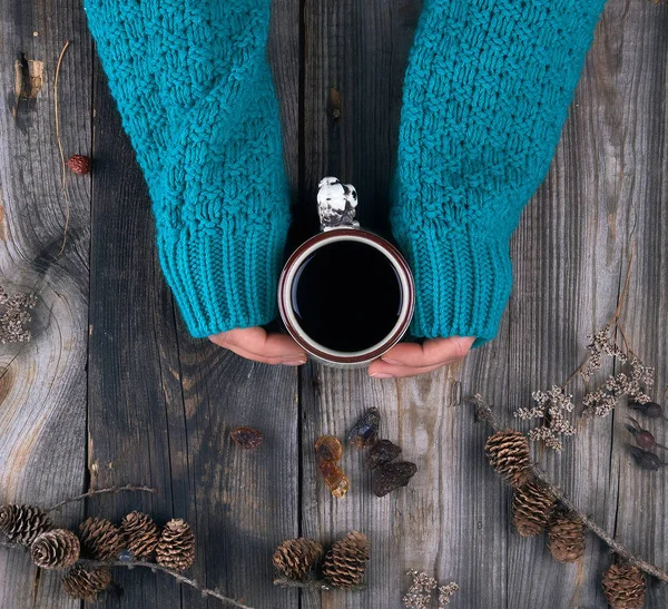 Female hands in a green knitted sweater holding a ceramic mug wi — Stock Photo, Image