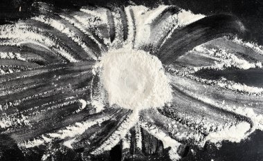 siyah bir masaya dağılmış beyaz buğday unu