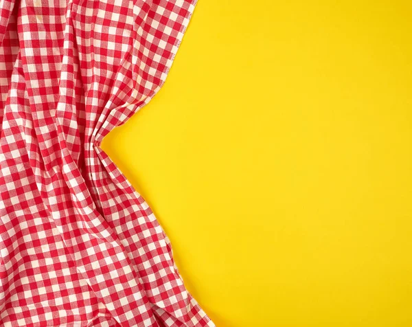 Toalla de cocina a cuadros rojo blanco sobre un fondo amarillo — Foto de Stock