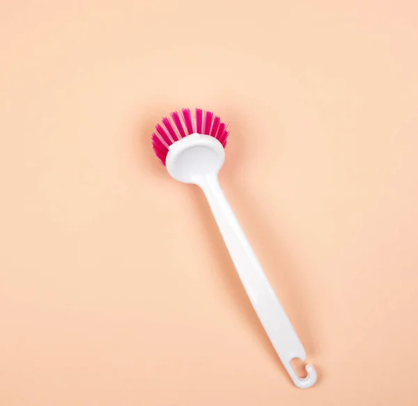 Kitchen brush with white plastic handle on a beige background — Stock Photo, Image