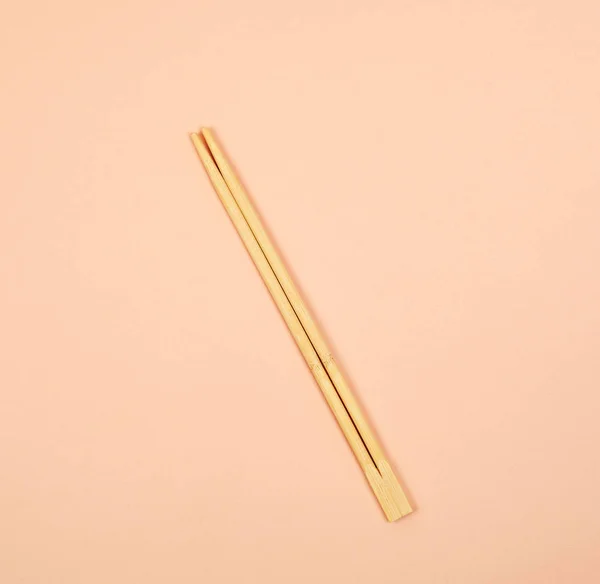 Two wooden chopsticks on a beige background — Stock Photo, Image