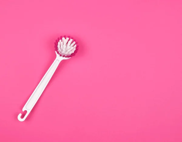 Szczotka kuchenna z białym plastikowym uchwytem na różowym tle — Zdjęcie stockowe
