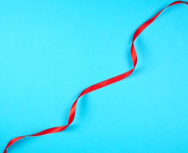 bükülmüş kırmızı ipek kurdele, mavi arka plan