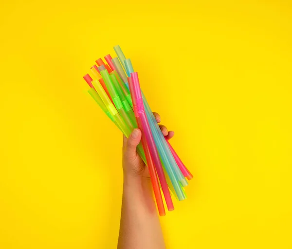 Female Hand Holding Multicolored Plastic Cocktail Tubes Yellow Background — Stock Photo, Image