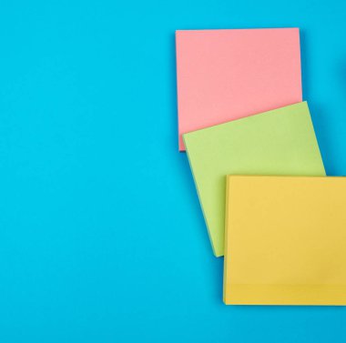 mavi arka planda çok renkli boş kağıt kare çıkartmalar