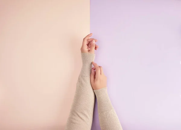 Två kvinnliga händer med ljus slät hud på en grön rosa bakgrun — Stockfoto