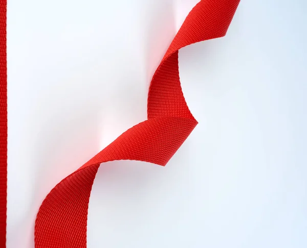 Скручений червоний текстильний пояс з грубим волокном на білому фоні — стокове фото