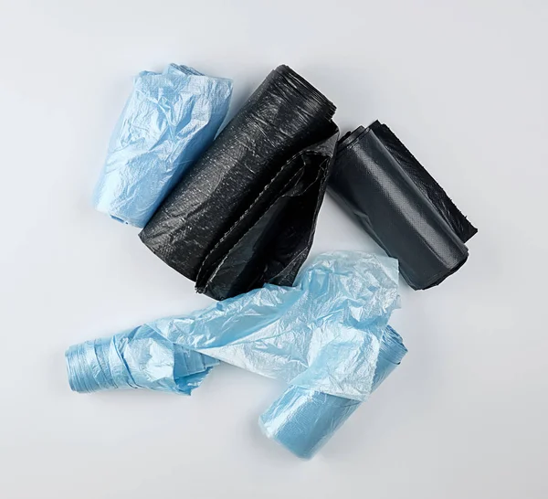Черный и синий пластиковые пакеты для мусорных баков на белом фоне — стоковое фото