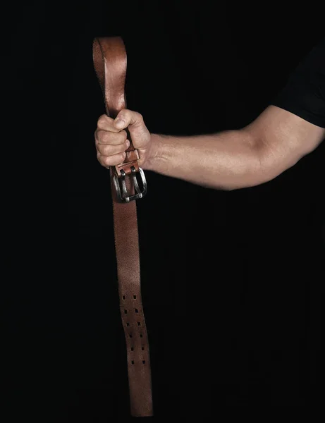 Cinto de couro marrom com uma fivela de ferro na mão de um homem — Fotografia de Stock
