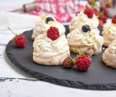 siyah grafit boa üzerinde krem şanti ile pişmiş yuvarlak bezeler