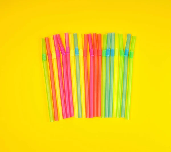 Multicolored plastic cocktail tubes on a yellow background — Stock Photo, Image