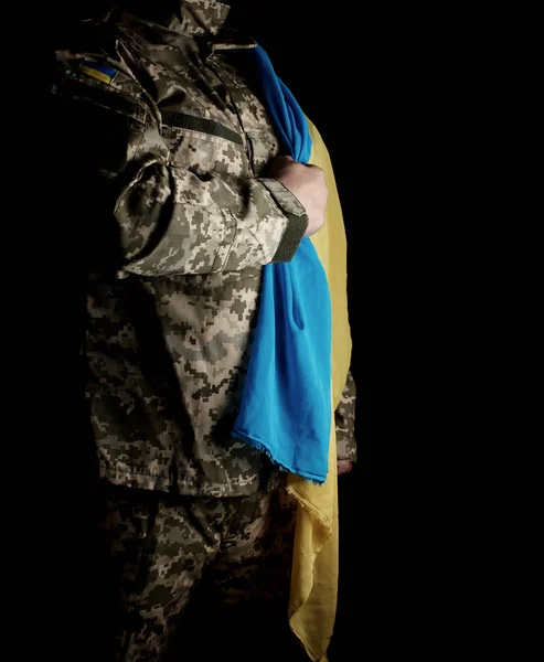 Soldat ukrainien tient dans sa main le drapeau jaune-bleu de la — Photo