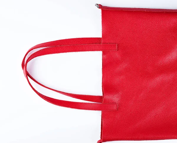 Фрагмент красной кожаной сумки с ручками на белом фоне — стоковое фото