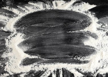 siyah bir masaya dağılmış beyaz buğday unu