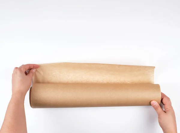 Rouleau de papier parchemin brun pour la cuisson des aliments dans les mains des femmes — Photo