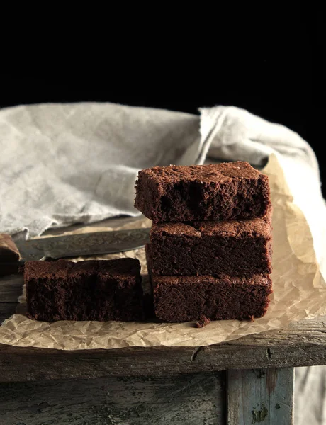 Pilha de pedaços quadrados assados de bolo de chocolate brownie em marrom — Fotografia de Stock