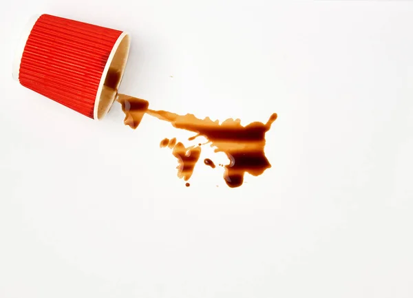 Beyaz bir arka plan üzerinde kırmızı bir kağıt fincan dökülen siyah kahve — Stok fotoğraf