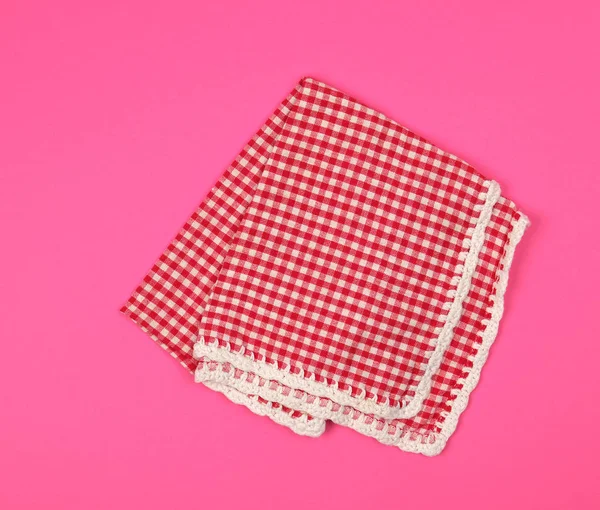 Складений червоний кухонний рушник в клітці на рожевому фоні — стокове фото