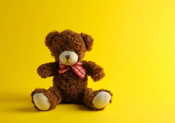 Bruine teddybeer zittend op een gele achtergrond — Stockfoto