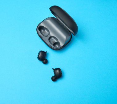 siyah kablosuz küçük kulaklık çifti ve bir şarj kutusu 