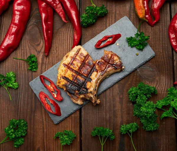 kaburga domuz kızarmış biftek siyah bir tahta üzerinde yatıyor