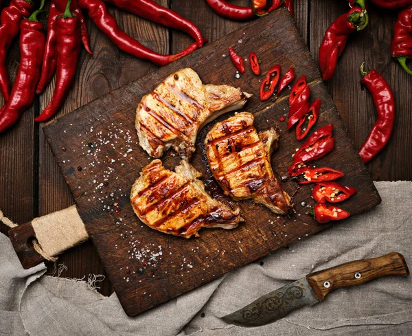 kaburga domuz kızarmış biftek bir vintage kahverengi ahşap tahta üzerinde yatıyor