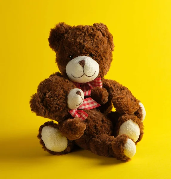 Two brown teddy bears on a yellow background — Stock Photo, Image