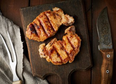 domuz kızarmış biftek bir vintage kahverengi ahşap tahta üzerinde yatıyor