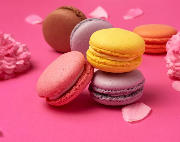 Macarons assados coloridos farinha de amêndoa em um fundo rosa — Fotografia de Stock