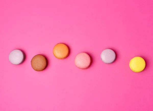 Macarons colorés au four farine d'amande sur un fond rose — Photo