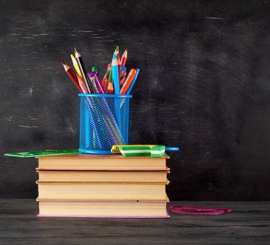 kitap yığını ve çok renkli wo ile mavi bir kırtasiye cam