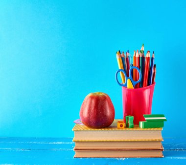 çok renkli ahşap kalemler ile kırmızı plastik fincan bir st duruyor