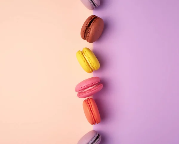Multi-gekleurde Macarons met crème op een paars-beige achtergrond — Stockfoto