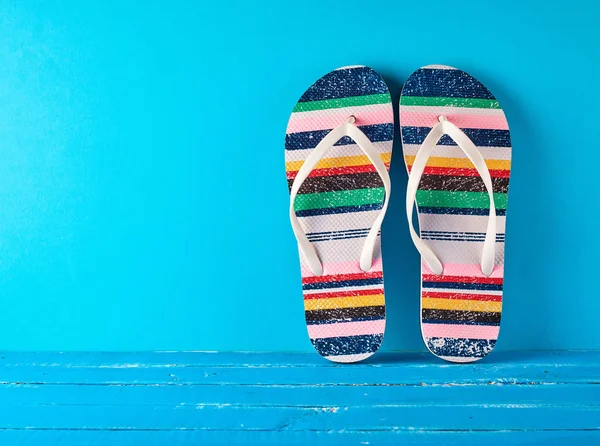 Coppia di pantofole da spiaggia femminili su sfondo blu — Foto Stock