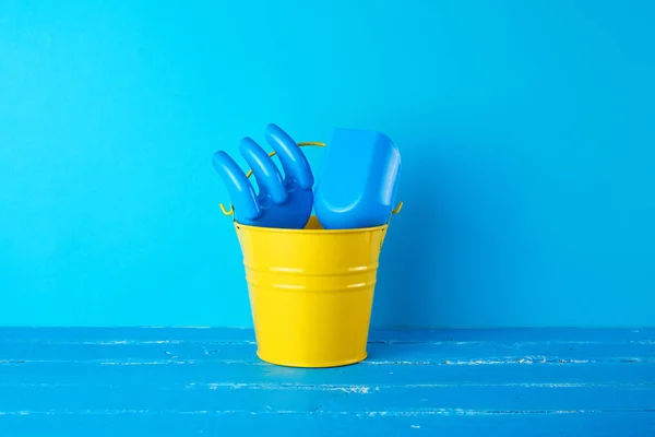 Žlutý dětský kbelík a plastová lopatka a hrábě — Stock fotografie