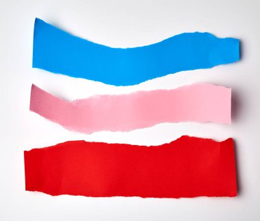 beyaz bir arka plan üzerinde kırmızı, pembe ve mavi yırtık kağıt şeritler