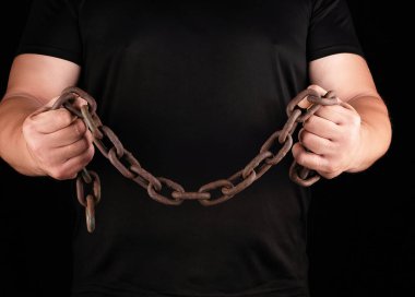 siyah giysiler içinde yetişkin adam gergin kasları ile dik duruyor 