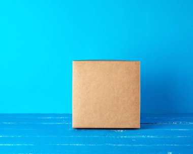 mavi arka plan üzerinde kapalı kare kahverengi hediye kutusu