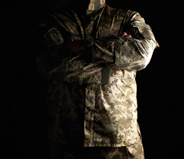 Ukrainian soldier in camouflage uniform stands with arms crossed — Stock Photo, Image