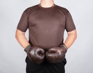 genç adam çok eski vintage kahverengi boks eldiven giyen duruyor