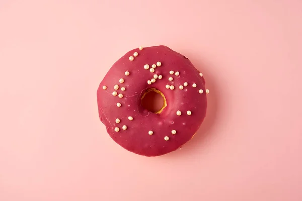 ピンクの背景に白い振りかける赤い丸いドーナツ — ストック写真