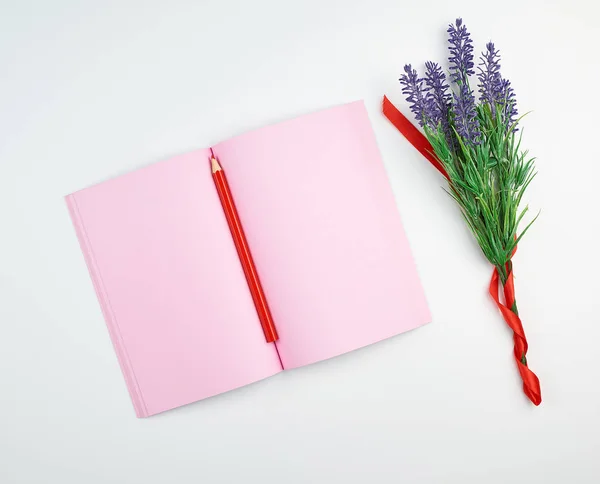 Cuaderno abierto con páginas de color rosa en blanco, lápiz rojo de madera —  Fotos de Stock